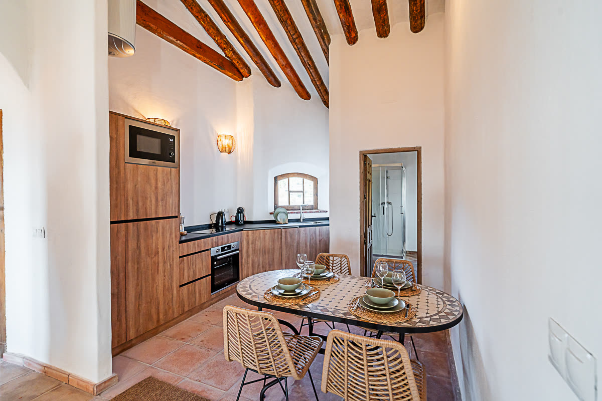 Cottage kitchen and dining area with exposed wood-beam ceiling