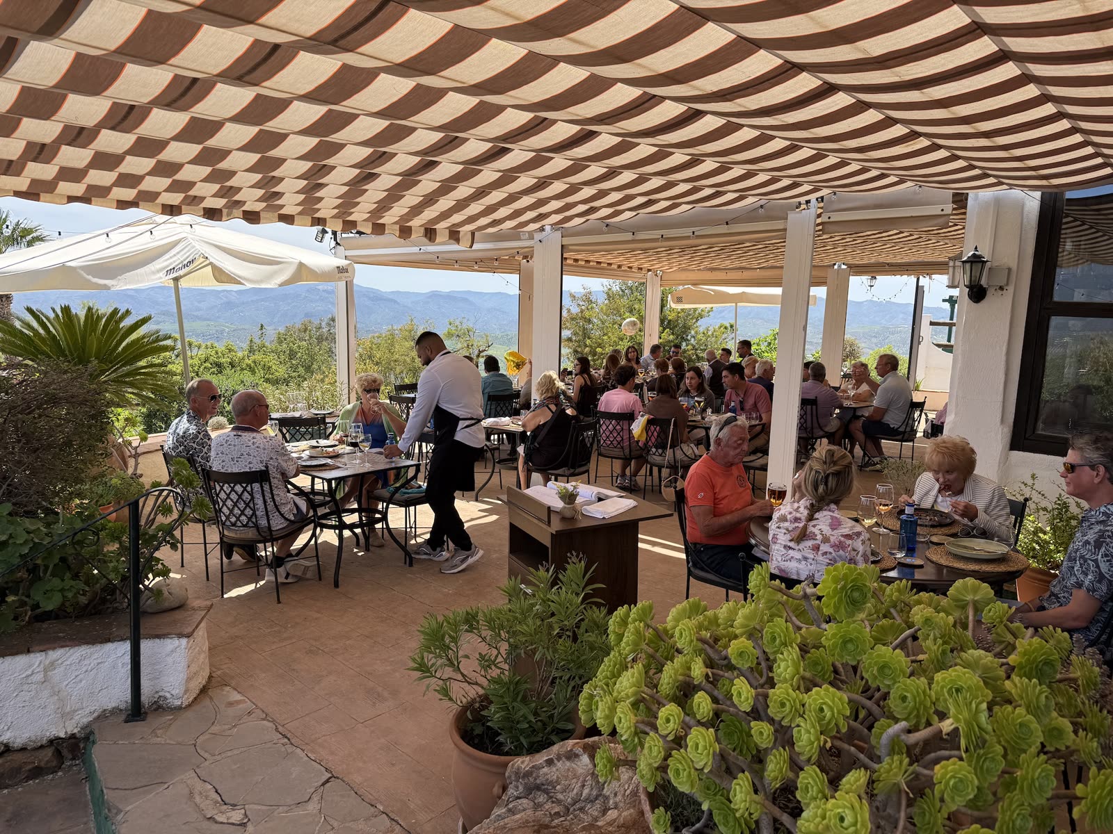 Guests dining on the covered terrace at Finca Cantueso with valley views